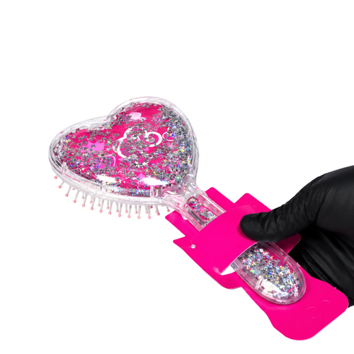 A heart-shaped hairbrush filled with pink glitter and holographic confetti